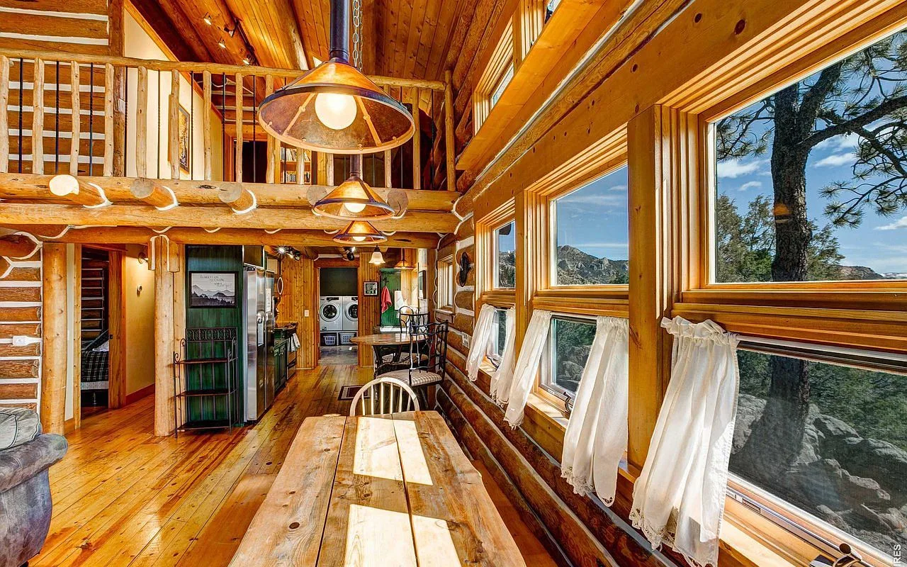 Sunlit dining area with hand-hewn log walls and mountain views at Range View on the Rocks