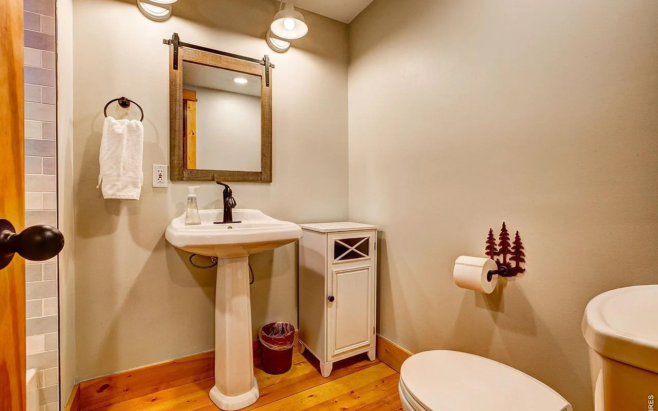 Guest bathroom with pedestal sink and barn-door mirror