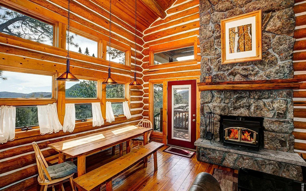 Window bench beside the stone fireplace with Rocky Mountain views through the great room windows